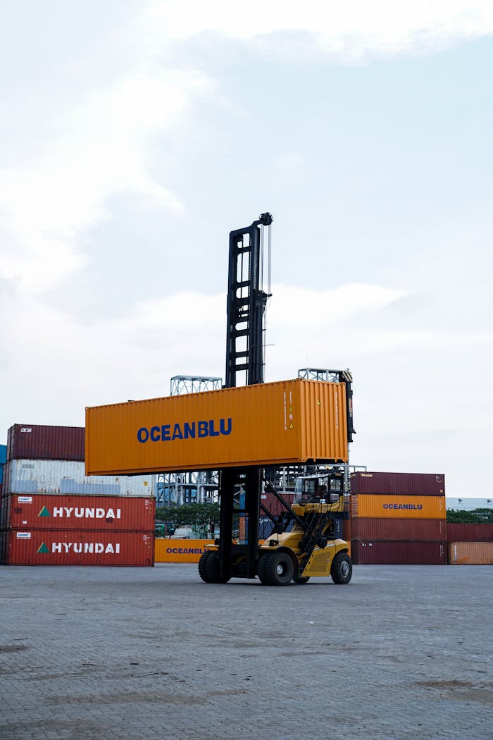 Forklift handling container in bustling Jakarta port with clear skies.